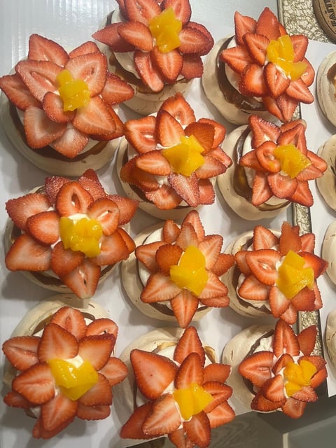 Strawberry flower-shaped desserts with yellow cream or custard centers arranged on white plates